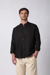 Camisa de manga larga confeccionada en lino, con cuello mao y cierre frontal de botones. Presenta un corte relajado y diseño minimalista.
