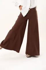 Pantalón de tiro medio con corte súper acampanado, confeccionado en gabardina con spandex. Presenta bolsillos delanteros y traseros, con cierre frontal de cremallera y botón.