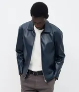 Campera de cuero sintético color azul marino, con cuello clásico, cierre frontal por cremallera y diseño minimalista de corte regular.