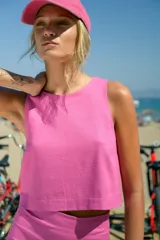 Top corto de lino color fucsia, con escote redondo cerrado y corte recto sin mangas.