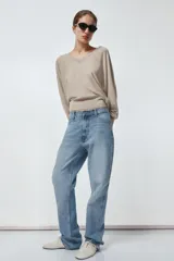 Pantalón de jean celeste de tiro alto, corte recto y largo hasta el tobillo. Tiene cinco bolsillos, trabillas en la cintura, efecto lavado y cierre frontal con cremallera y botón.