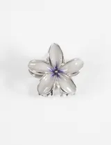 Broche metálico plateado en forma de hibisco con acabado brillante y detalles en color blanco y violeta.