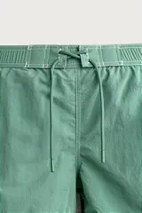 Short de baño verde con cintura elástica ajustable con cordón, bolsillos laterales y pespuntes en contraste.