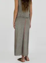 Pollera larga de tejido de lino color gris con costuras verticales rojas.