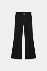 Pantalón de tiro alto confeccionado en crepe, con corte evasé y diseño de pernera ancha. Cuenta con trabillas en la cintura, cinturón ajustable del mismo tejido con hebilla metálica y cremalleras laterales ocultas en el bajo.