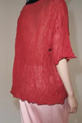 Top rojo de punto con textura efecto arrugado, cuello redondo y mangas cortas holgadas.