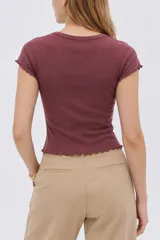 Remera manga corta de algodón con elastano, de diseño al cuerpo con escote en V y terminaciones con volados sutiles en mangas y ruedo.