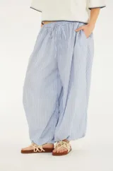 Pantalón aladín de algodón con rayas finas azules y blancas, cintura ajustable con cordón y elástico, bolsillos funcionales y puños elásticos en los tobillos.