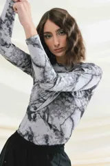 Top negro de mangas largas con frunces en el hombro izquierdo.