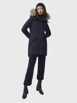 Parka azul marino con capucha con ribete de piel, cierre frontal con botones y bolsillos laterales con solapa.