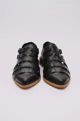 Sandalias bajas de cuero color dorado con tiras entrecruzadas y hebillas ajustables. Taco de madera.