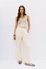 Pantalon palazzo de tiro alto, confeccionado en cupro con textura sedosa. Presenta un diseño de corte fluido, largo al piso y bolsillos laterales.