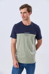 Remera de algodón y poliéster de corte clásico, con diseño en bloques de color negro en la parte superior y gris melange en la inferior. Presenta cuello redondo, mangas cortas y un pequeño estampado tipográfico en el pecho.