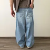Pantalón jean de corte barrel, color azul clásico con efecto desgastado y diseño amplio y curvado en las piernas.