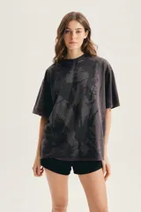 Remera oversize de algodón negro, con cuello redondo, mangas cortas y estampa frontal con efecto espejado.