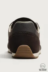 Zapatilla deportiva barefoot de hombre, confeccionada en combinación de piezas de piel con acabado serraje en color marrón, con cordones y suela fina de goma en contraste.