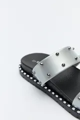 Sandalias plateadas con doble tira ancha y microtachas metálicas.