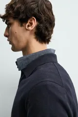 Sweater polo de punto de mezcla de algodón en color negro, con cuello solapa, abertura frontal y mangas largas con acabado en rib.