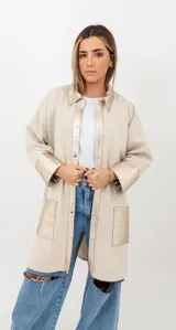 Camisa tipo sobrecamisa de lana en color beige, con detalles en cuero metalizado dorado en cuello, solapa frontal, puños y bolsillos. Presenta cierre frontal con botones a presión.