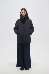 Campera puffer de cuello alto, manga larga y ajuste holgado, con cierre frontal oculto y bolsillos laterales.