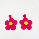 Aros colgantes con forma de flor, hechos con rafia color beige y centro amarillo.