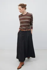 Falda larga de jean color azul oscuro con corte evasé y costuras con pespuntes a contratono. Presenta una cintura elástica para mayor comodidad.