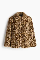 Campera de piel sintética con estampado de leopardo, cuello clásico, hombreras y cierre frontal con corchetes. Presenta bolsillos laterales ocultos y un corte con ligero vuelo en el bajo.