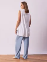 Blusa blanca sin mangas de lino, marca Zac & Rachel. Cuello con solapa, escote en V y abertura central con botones. Delantera con bolsillos aplicados. Laterales con botones aplicados.
