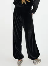 Pantalon de terciopelo negro de corte holgado y tiro alto, con bolsillos laterales.
