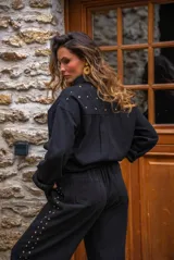 Camisa de denim negra con botones metálicos dorados y bolsillos con tachas doradas. De corte amplio.