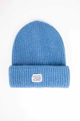 Gorro beanie de punto acanalado color celeste con vuelta y etiqueta blanca frontal con la inscripción "Piece of Cake".