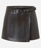 Short pollera de tiro alto confeccionado en poliuretano con acabado que imita el cuero. Presenta un diseño cruzado tipo falda con cinturón integrado de hebilla metálica y cierre oculto.