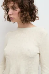 Blusa color crema de punto 100% algodón, con cuello redondo y mangas largas acampanadas.