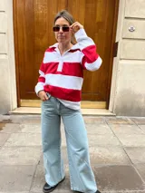 Sweater de algodón a rayas horizontales rojas y blancas, con cuello polo y cierre parcial con botones.