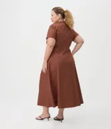 Vestido midi de tricolina de algodón color marrón, con escote en V, cuello mao, mangas cortas, cierre frontal con botones y pliegues en la falda.