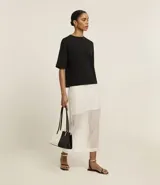 Blusa básica de algodón con corte oversized, cuello redondo y mangas cortas con sisas desplazadas. Diseño liso sin estampados.