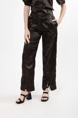 Pantalón negro de seda con tiro alto, corte recto, pinzas en la pretina y tajos en el ruedo.