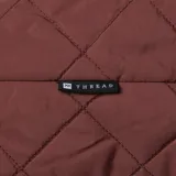 Bolso tipo hobo o baguette de tela acolchada color marrón oscuro, con costuras en patrón de rombos. Posee un bolsillo exterior frontal y una correa de hombro ajustable con argolla metálica.