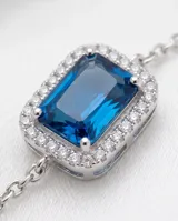 Pulsera de plata 925 con diseño de cadena fina y dije central rectangular con una circonia azul rodeada de pequeñas circonias blancas.