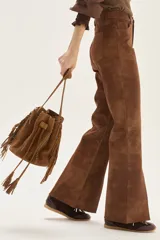 Pantalón wide leg de cuero sintético color marrón, con tajo frontal en el ruedo y cierre de botón y cremallera.