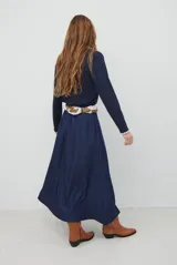 Falda larga de jean color azul oscuro con corte evasé y costuras con pespuntes a contratono. Presenta una cintura elástica para mayor comodidad.