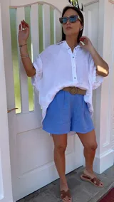 Short de lino color rojo, con cintura elástica y cinturón de rafia con hebilla circular.