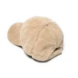 Gorro tipo gorra con visera, confeccionado en tejido de textura suave y afelpada, color beige.