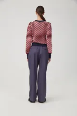 Pantalón negro de gabardina liviana de algodón, tiro alto con pinzas delanteras, bolsillos americanos y cierre metálico.