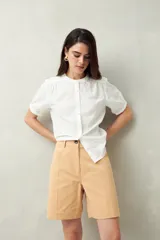 Bermuda color beige, de tiro medio y calce relajado, confeccionada en algodón.