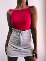 Crop top negro con textura brillante, breteles anchos con volados y espalda descubierta que se ata con lazos.