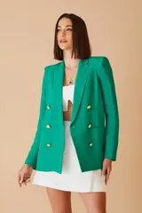 Blazer verde en crepe con solapas de muesca y cierre frontal con doble botonadura dorada.
