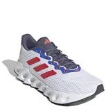 Championes de running Adidas Switch Run, con diseño moderno en color blanco, detalles en azul, rojo y gris oscuro. Presentan una entresuela de EVA con diseño de rebajes y suela Adiwear para mayor tracción.