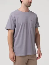 Remera de cuello redondo y manga corta en color gris, con un bolsillo aplicado en el pecho que presenta un pequeño bordado de un pato en color contrastante.