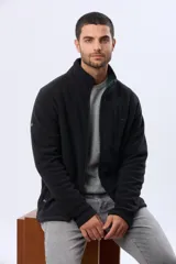Campera polar de abrigo color negro, con cuello alto, cierre frontal completo y bolsillos laterales con cierre. Cuenta con un bolsillo vertical con cierre en el pecho y elástico en los puños.